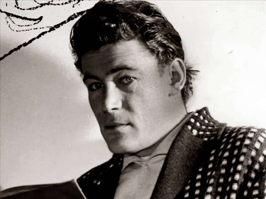 Um homem de casaco xadrez e gravata olhando para a câmera em um retrato de estúdio preto e branco. — Peter O'toole Papéis de Parede