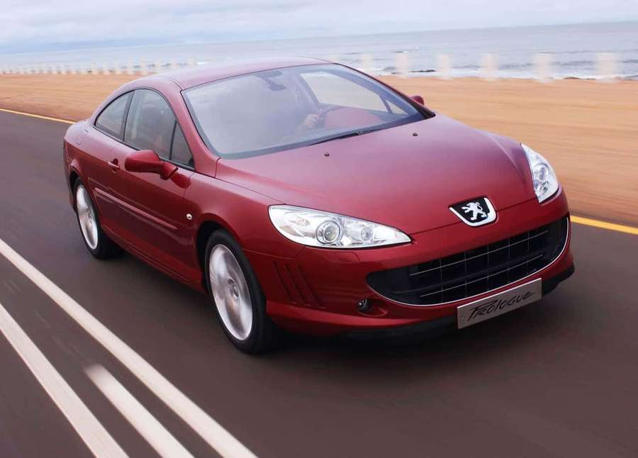 Red Peugeot 407 coupe driving on coastal road at sunset. — Peugeot 407 Wallpaper