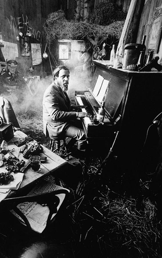 Man speelt piano in een donkere rokerige rustieke kamer met hooi en kranten. — Telefoon Achtergronden