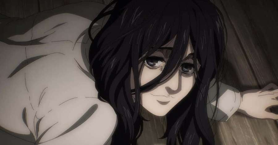 Anime girl with dark hair smiling while lying on wooden floor. — Pieck Finger Wallpaper