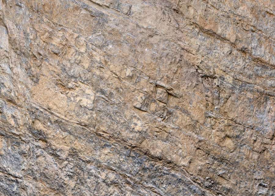 Pared rocosa rugosa y texturizada con estrías estratificadas y tonos terrosos. — Piedra Marrón Fondos de pantalla