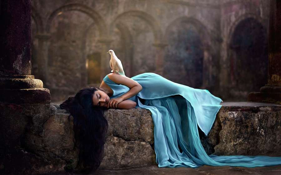 Uma mulher em um vestido azul dorme em degraus de pedra com uma pomba branca no ombro. — Pilar Papéis de Parede