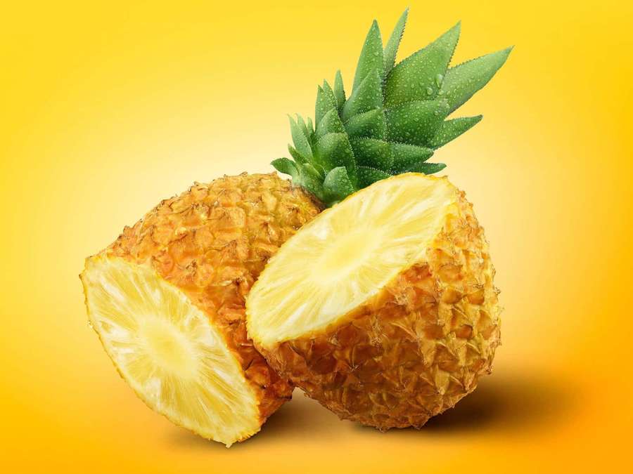 A sliced pineapple with green crown on a yellow gradient background. — Pineapple Desktop Background