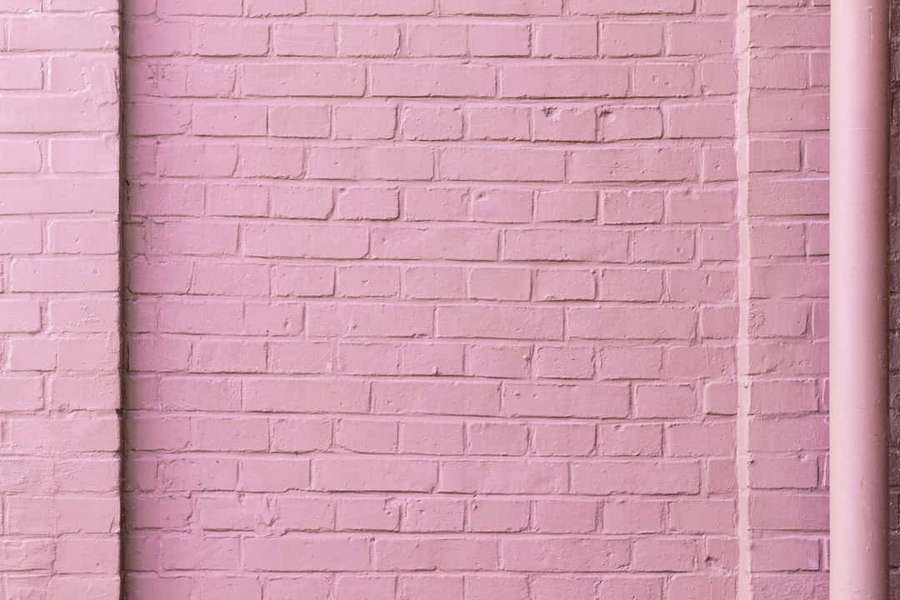 Pink painted brick wall with vertical pipe — Pink Brick Background