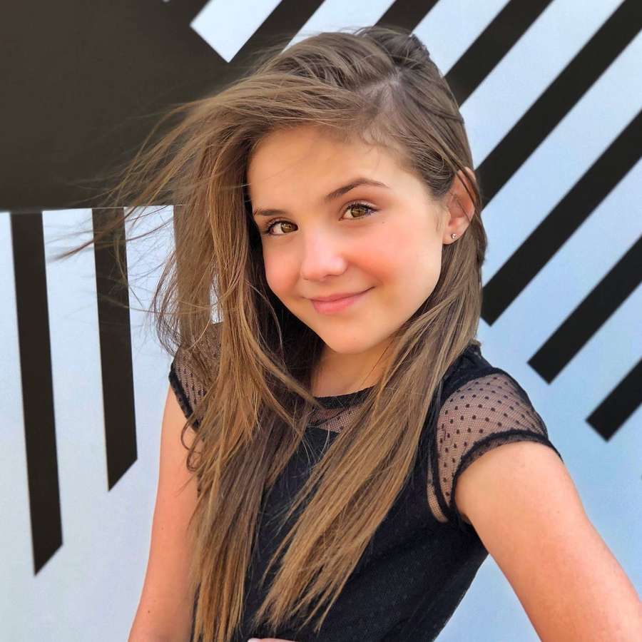 Young girl with long brown hair smiling in front of striped wall — Piper Rockelle Background