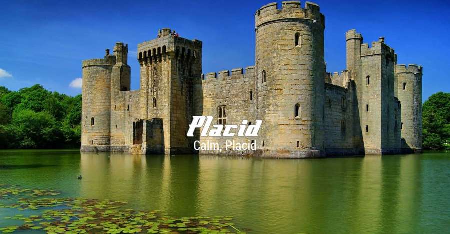 Stone castle surrounded by water and trees on a sunny day. — Placid Wallpaper