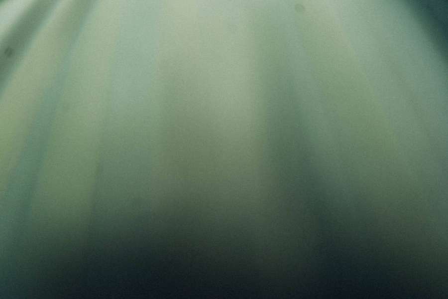 Serene underwater scene with soft green and blue light rays filtering through water. — Plain HD Wallpaper
