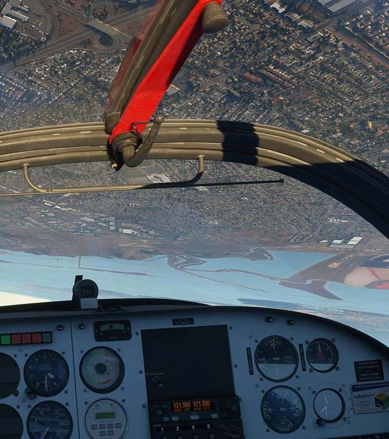 Vista do cockpit do avião mostrando cidade e água abaixo — Plano de fundo do Android Microsoft Flight Simulator Fundos