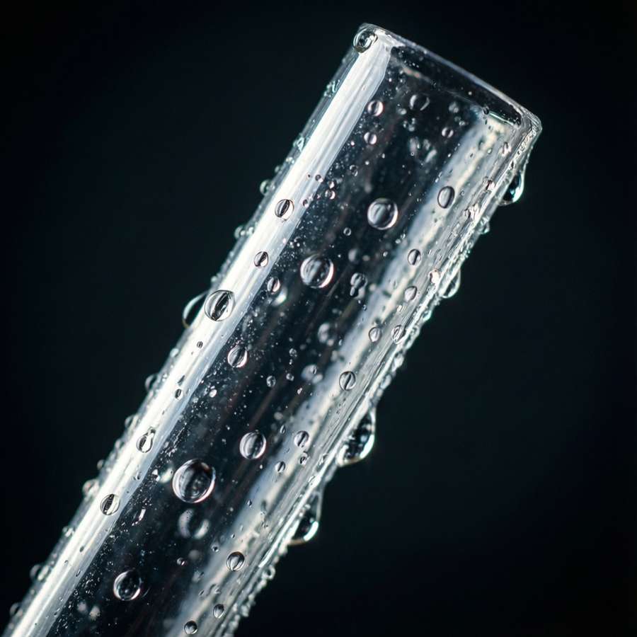 Extreme macro of a clear plastic straw filled with water droplets, dark dramatic lighting. — Plastic Straw Wallpaper