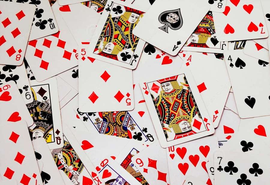 Scattered playing cards with red hearts black spades and royal figures — Playing Cards Background