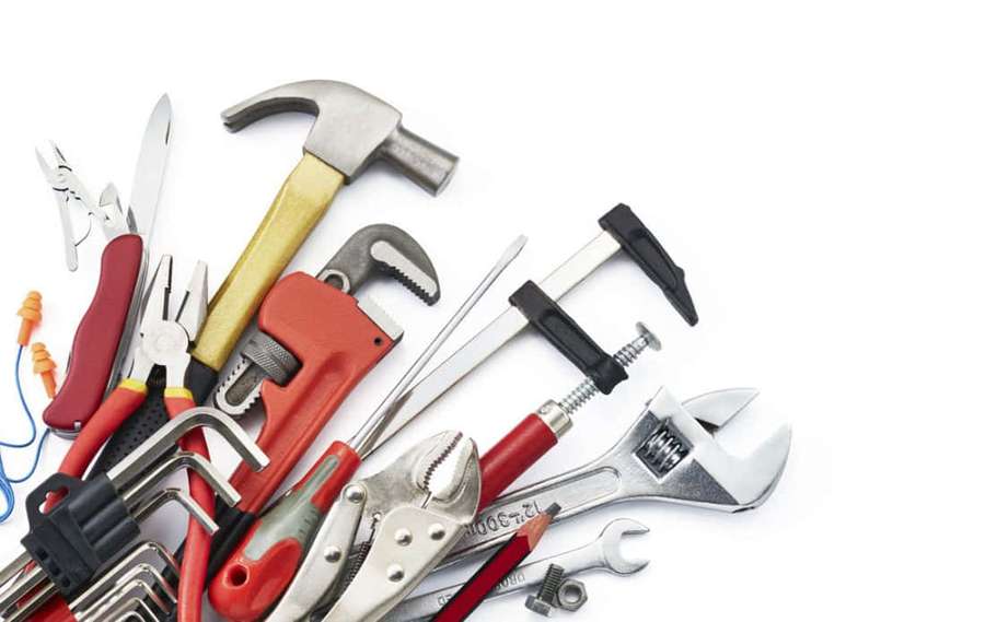 Assorted hand tools like hammers wrenches and pliers on a white surface. — Plumbing Background