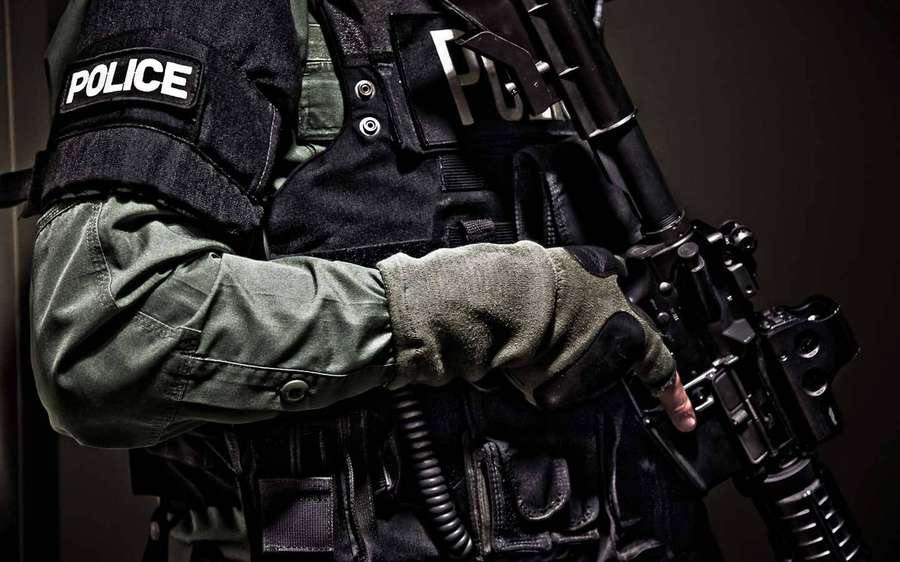 Polizist in taktischer Ausrüstung, der ein Gewehr hält. — Polizeibeamter Wallpaper