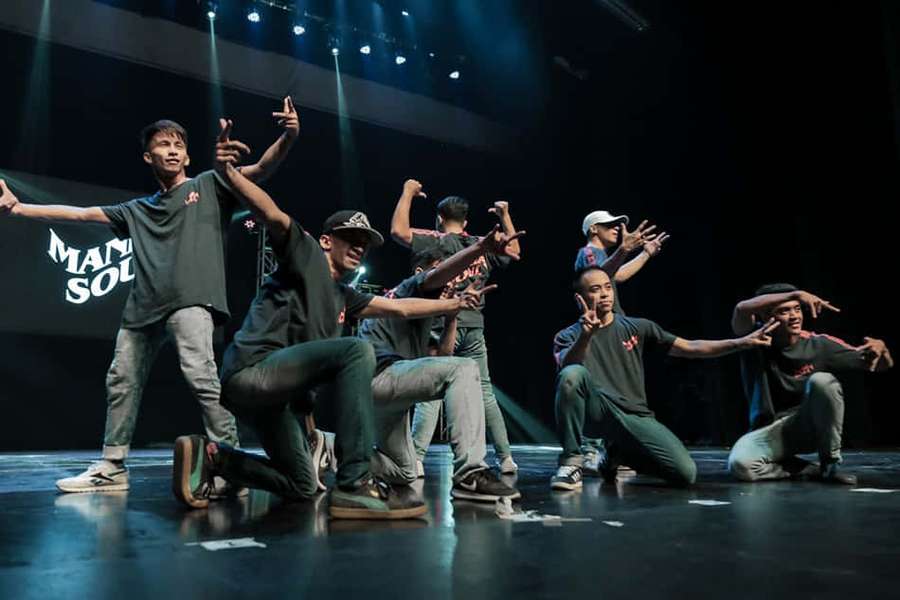 Dancers in coordinated poses under stage lights during a performance. — Popping Wallpaper