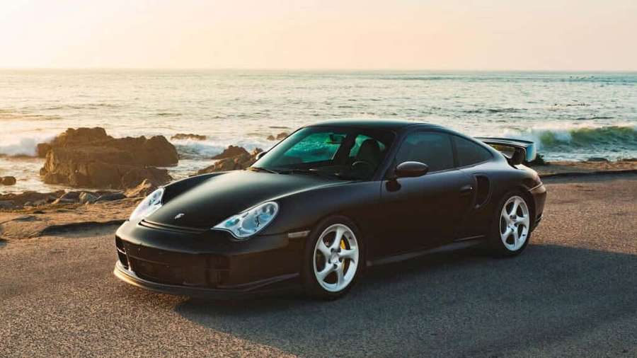 Black Porsche 911 Turbo parked on a seaside road at sunset. — Porsche 996 Wallpaper