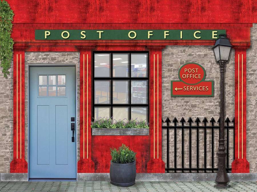 Red post office with blue door and stone walls under a streetlamp. — Post Office Wallpaper