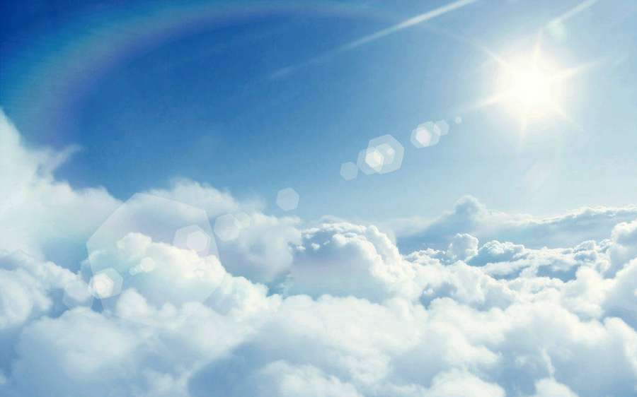 Rayos de sol brillan a través de nubes blancas y esponjosas en un cielo azul claro. — Powerpoint Fondos de pantalla