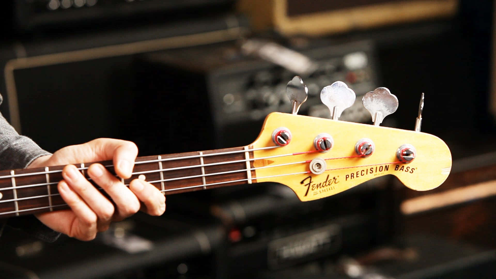 Käsi soittaa Fender Precision Bass -kitaraa musiikkistudiossa. — Tarkka Taustakuvat