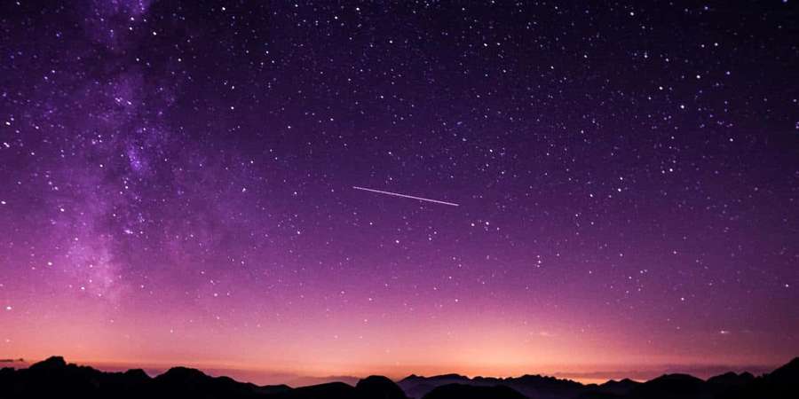 Purple and pink twilight sky with stars and a shooting star over mountain silhouettes. — Preliminary Wallpaper
