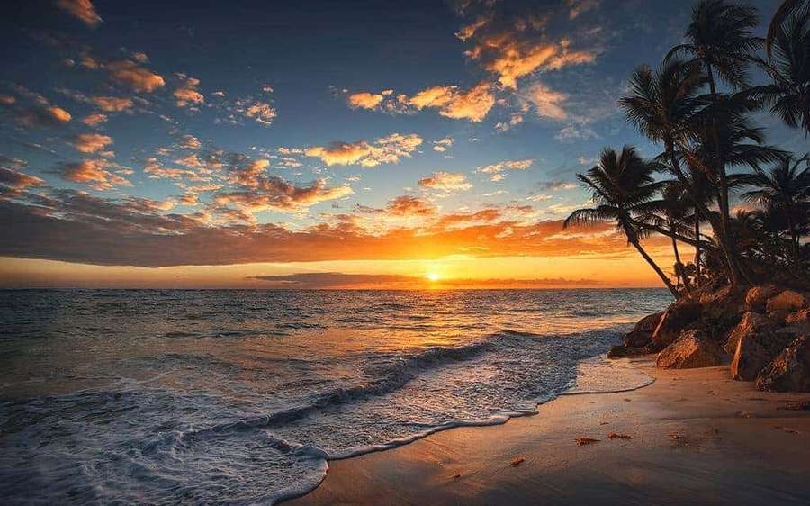 Sunset over tropical beach with palm trees and gentle waves — Pretty Sunset Picture