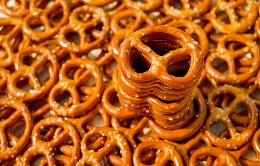 Stack of salted pretzels surrounded by more pretzels in a pile. — Pretzel Wallpaper
