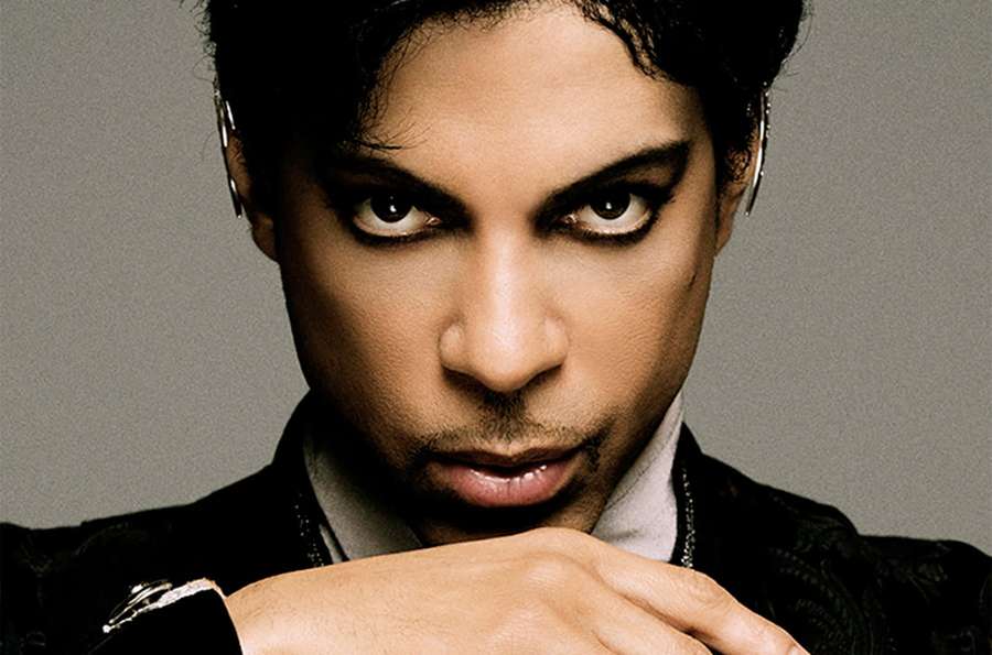Prince in a studio portrait with intense gaze and silver hoop earrings. — Prince Picture
