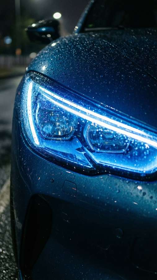 Close-up of Proton Gen-2 headlight glowing blue at night. — Proton Gen-2 Wallpaper