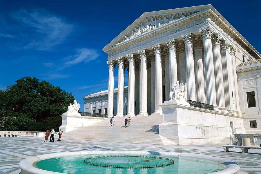 Supreme Court building with marble columns and fountain under sunny sky. — Punitive Picture