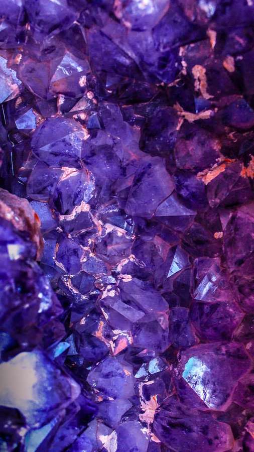 Close-up of purple amethyst crystal cluster with sharp facets and glowing highlights. — Purple iPhone Background