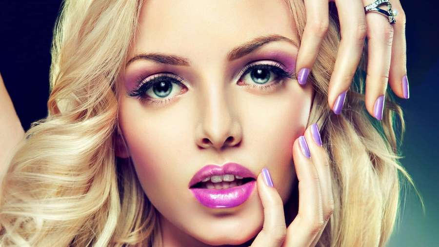 Close-up portrait of a blonde woman with purple makeup and nails. — Purple Nails Wallpaper