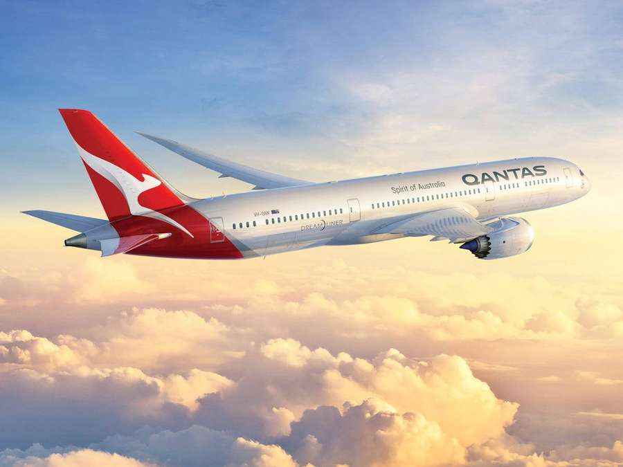 Qantas airplane flying above golden clouds at sunset. — Qantas Wallpaper