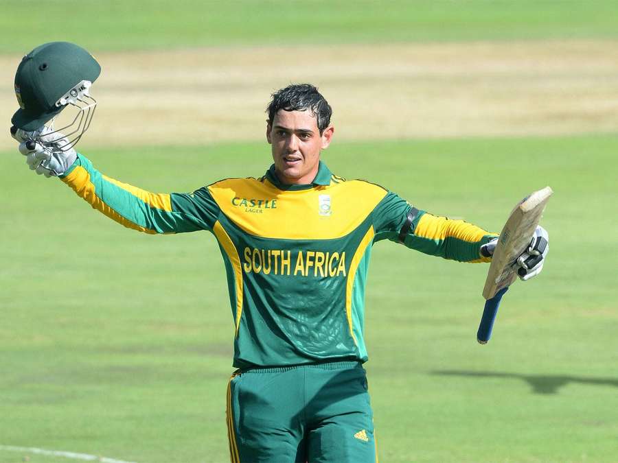 South African cricket player celebrating with helmet and bat on grass field — Quinton De Kock Wallpaper