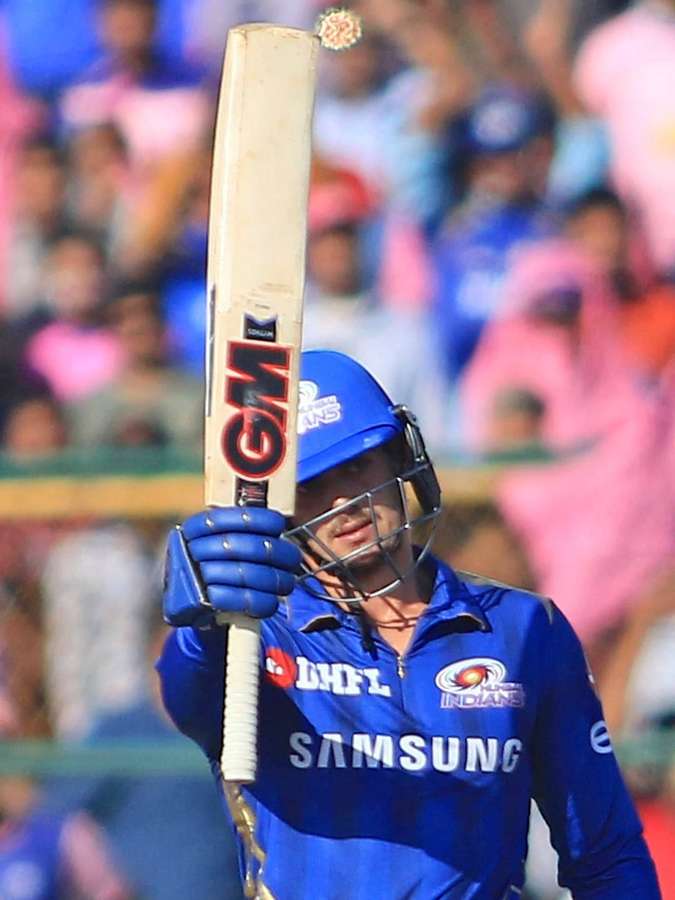 Cricketspieler in blauem Trikot feiert mit erhobenem Schläger während eines Tagespiels. — Quinton Wallpaper