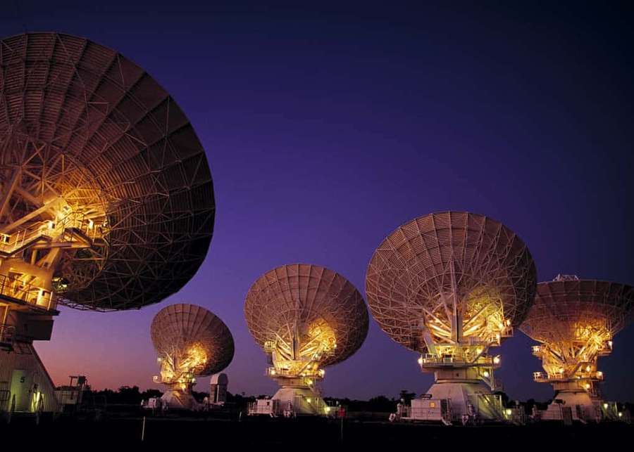 Cinco grandes radiotelescopios iluminados al atardecer contra un cielo púrpura. — Radio Telescopio Fondos de pantalla