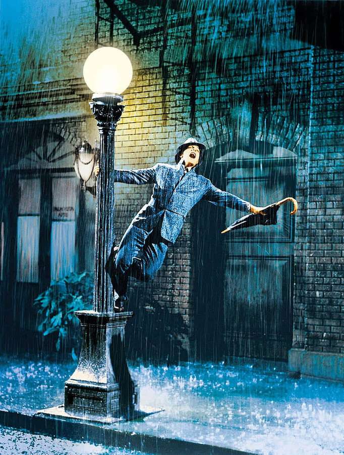 Man dancing in rain under streetlamp on wet sidewalk — Rain Dance Wallpaper