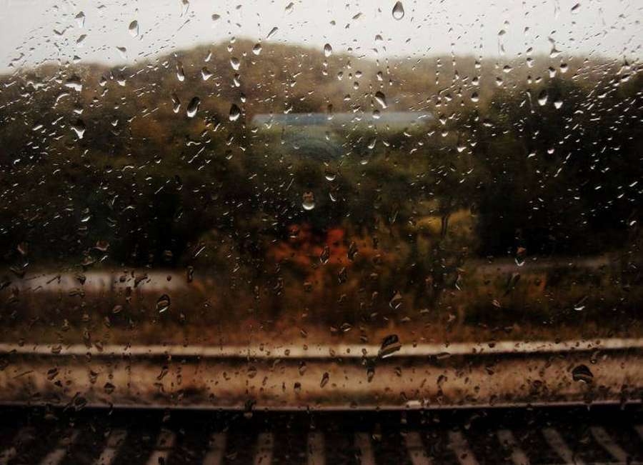 Gouttes de pluie sur la vitre d'un train montrant des arbres d'automne et des voies flous. — Raining Fonds d'écran