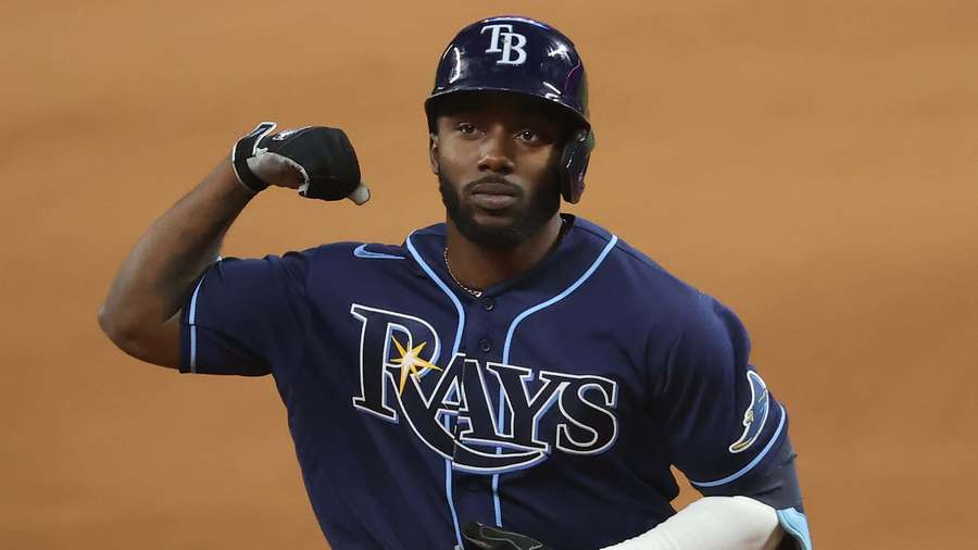 Tampa Bay Rays baseball player flexing his bicep on a dirt field. — Randy Arozarena Wallpaper