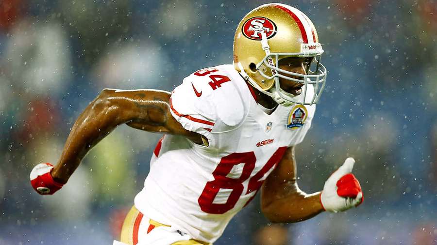 Footballspieler läuft im Regen während eines Spiels — Randy Moss Wallpaper