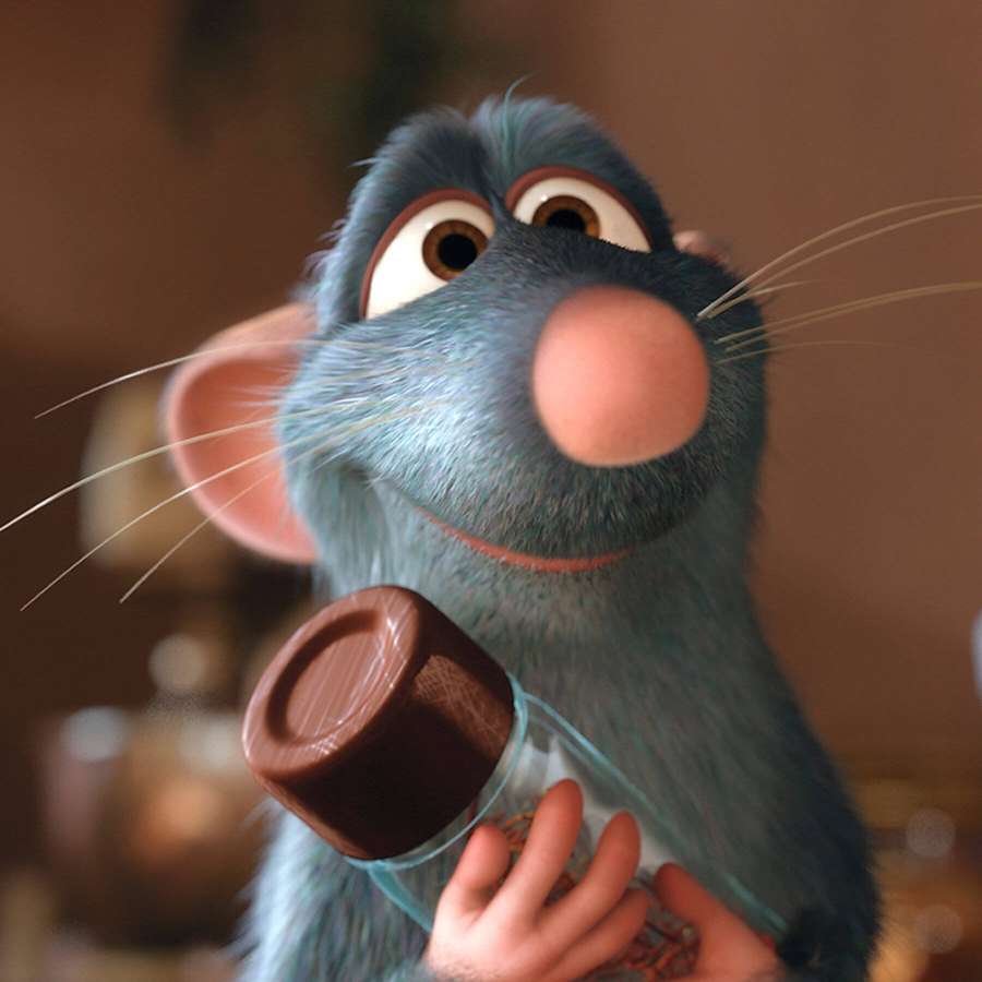 A blue animated rat holding a chocolate bottle with a happy expression. — Ratatouille Background