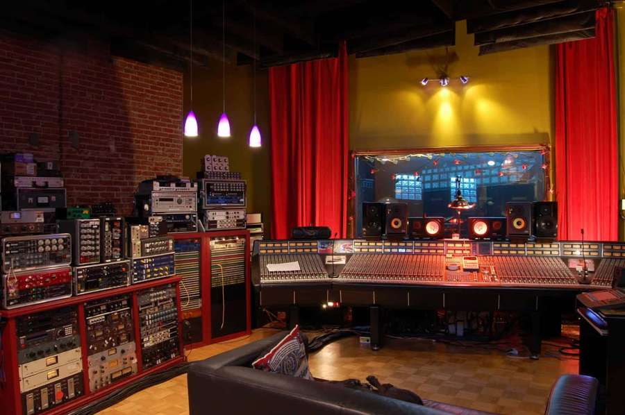 Professional music studio with mixing console and vintage audio gear under purple lights. — Recording Studio Background