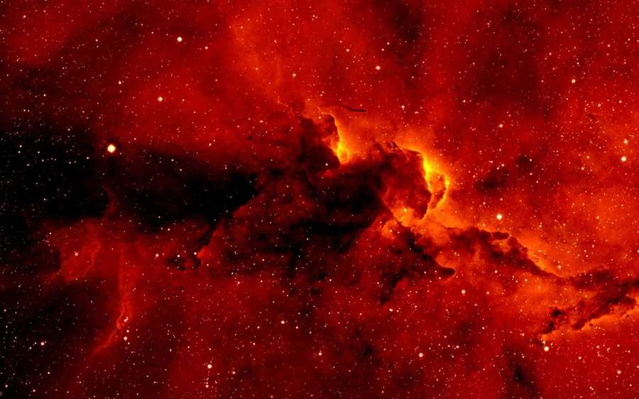 A red nebula with glowing orange cores and scattered stars in deep space. — Red Space Background