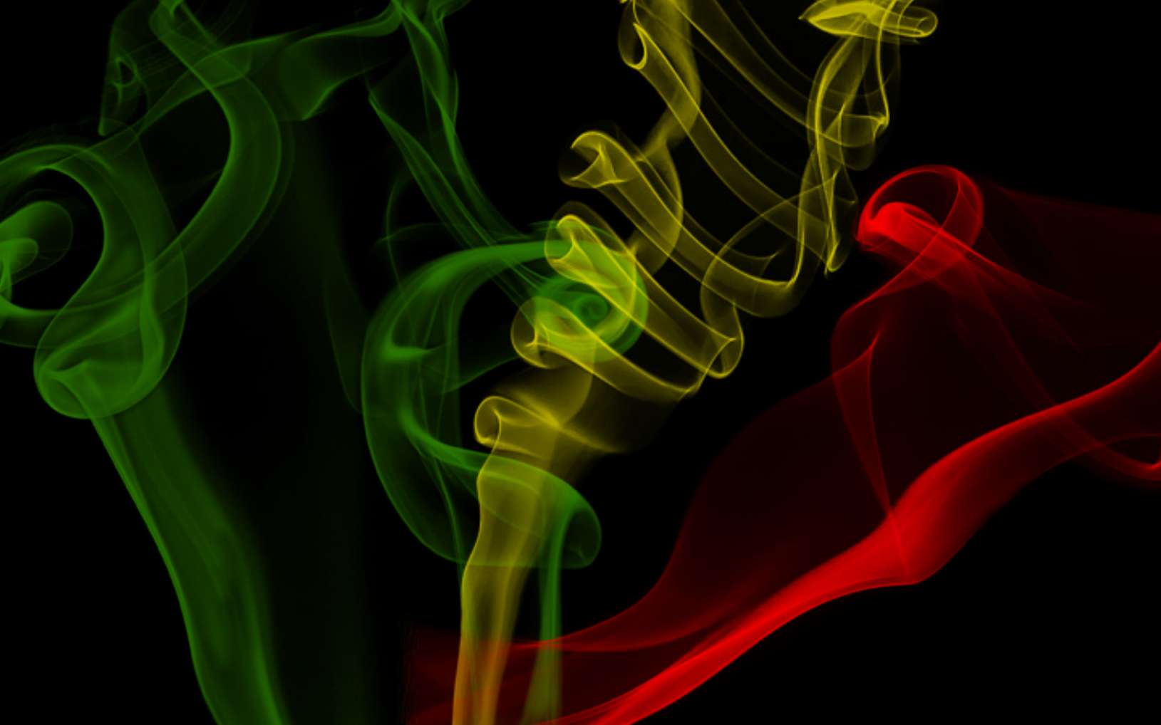 Colorful smoke streams in green yellow and red against a black background. — Reggae Background