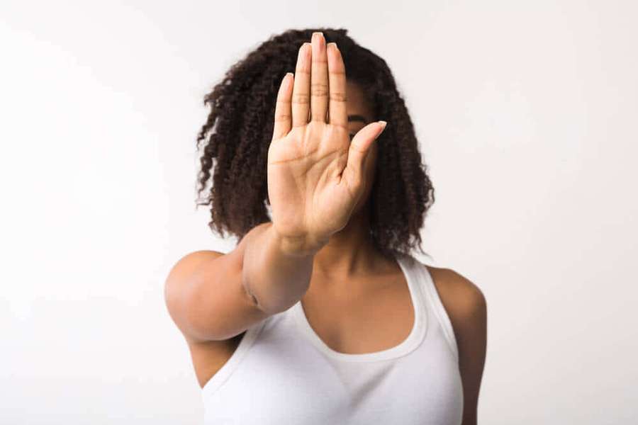 Woman holding hand up to signal stop in studio setting — Reluctant Wallpaper