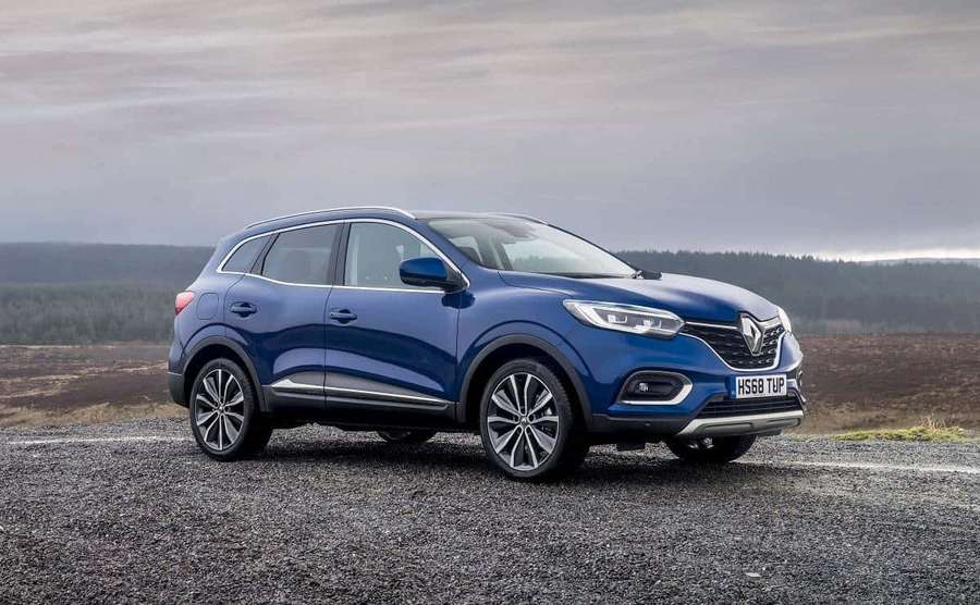 Sininen Renault-maastoauto pysäköitynä soralle metsäisten kukkuloiden lähellä pilvisellä taivaalla. — Renault Kadjar Taustakuvat