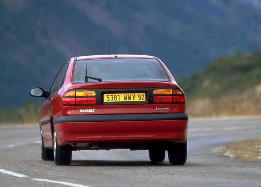 Punainen Renault Laguna sedan ajaa vuoristotiellä auringonlaskun aikaan. — Renault Laguna Taustakuvat