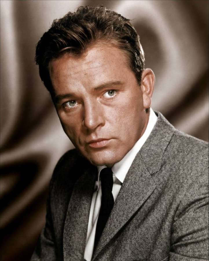 A man in a gray suit and black tie with a serious expression. — Richard Burton Wallpaper