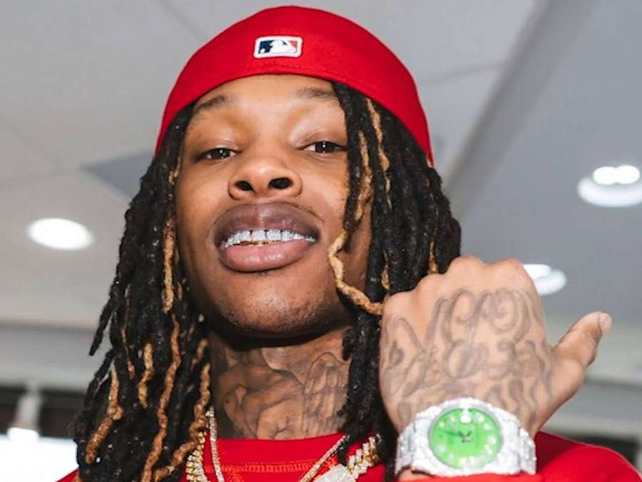 Man with dreadlocks wearing red cap and gold chains showing off diamond watch. — Rip King Von Wallpaper