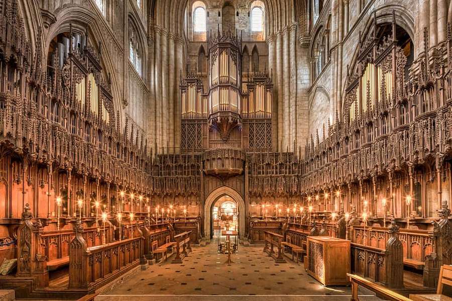 Ein Kathedraleninneres mit Holzbänken und einer großen Orgel, beleuchtet von Kerzenlicht. — Ripon United Kingdom Wallpaper