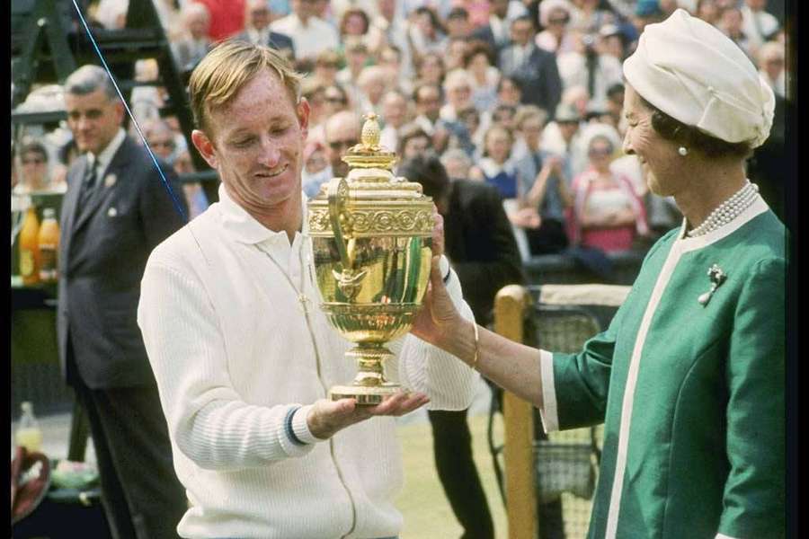 Tennis champion receives golden trophy from royal figure at outdoor event. — Rod Laver Wallpaper