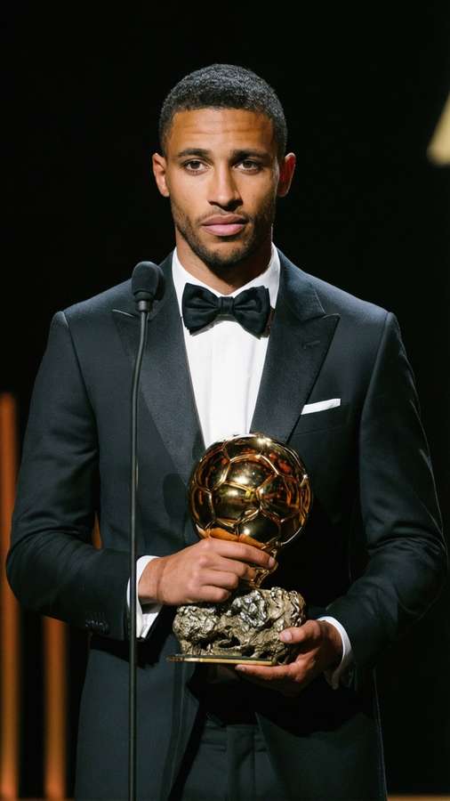 Man in tuxedo holding golden soccer award trophy on stage. — Rodri Picture
