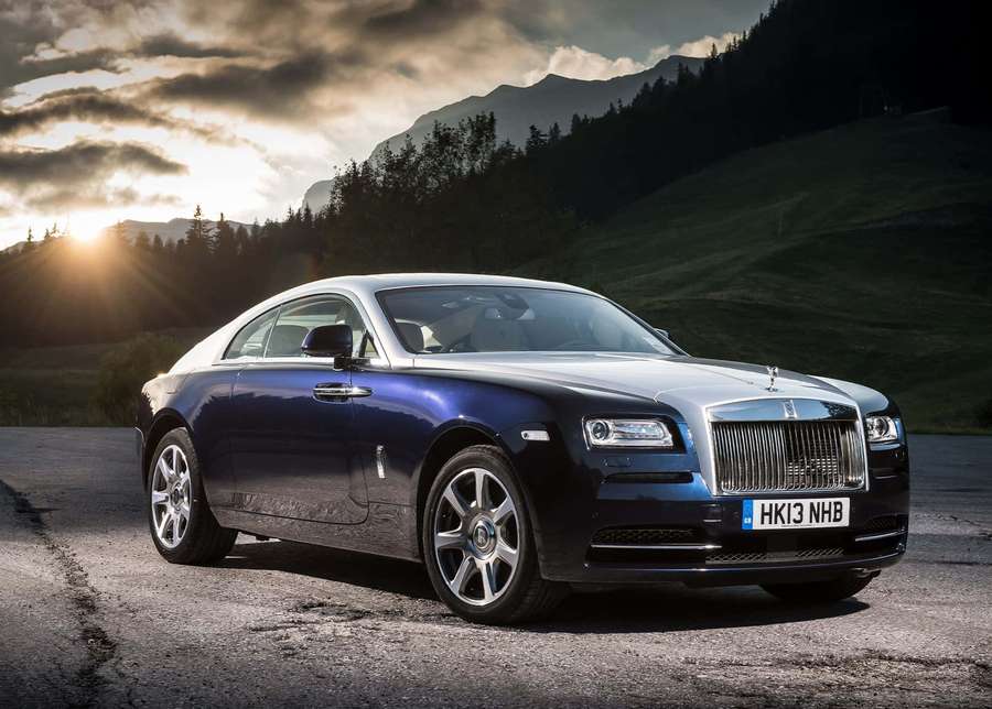A blue Rolls Royce parked on a mountain road at sunset. — Rolls Royce Background